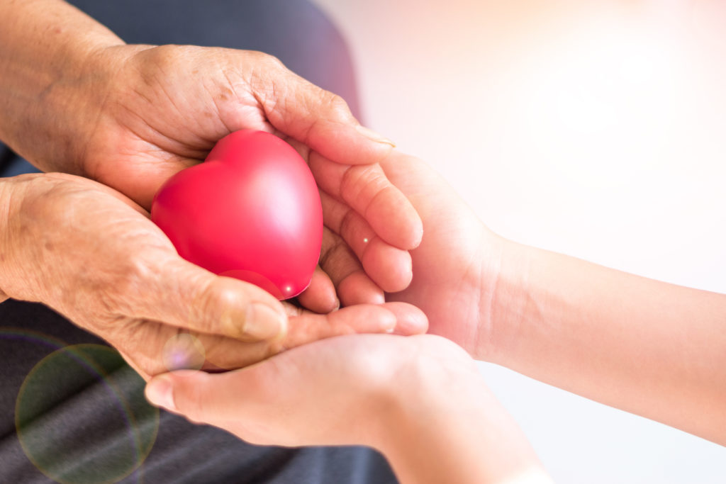 Building a Compassionate Hospice Care Team—elderly hands in younger womans hands holding a rounded heart